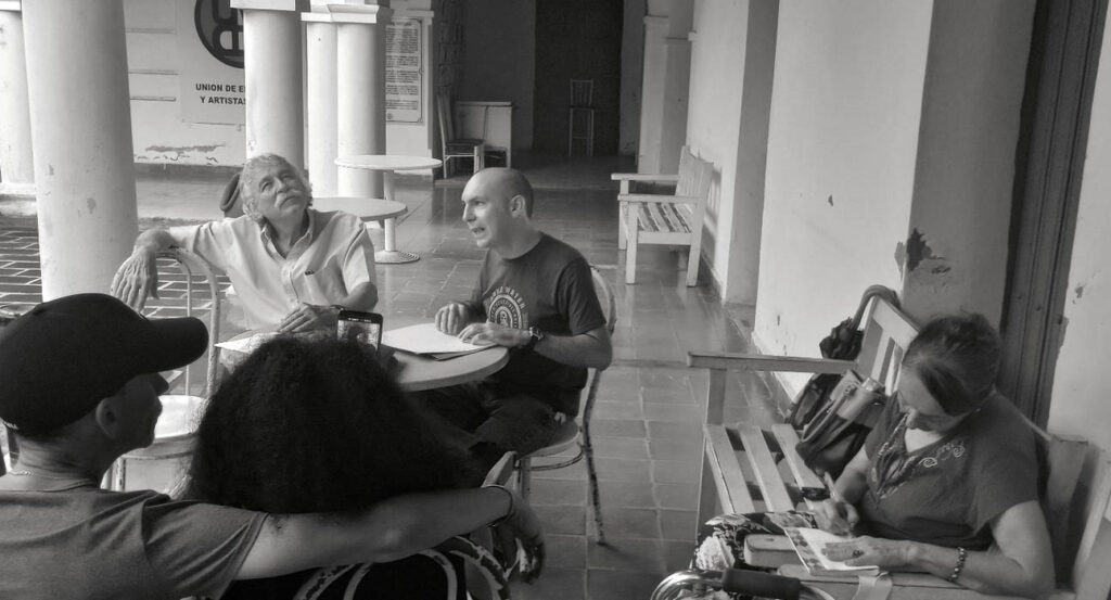 Hugo lee su poesía en el Café Literario cuyo anfitrión es el poeta Manuel García Verdecia (sentado a su derecha). Foto: Irela Casañas