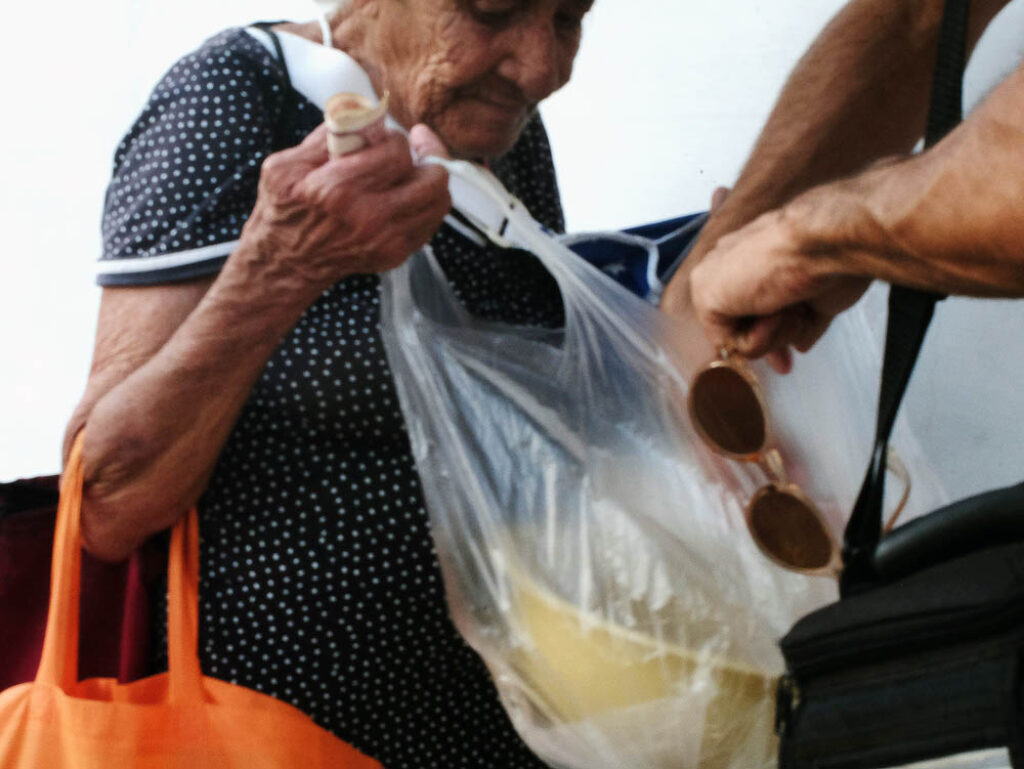 Anciana cubana vendiendo dulces caseros.