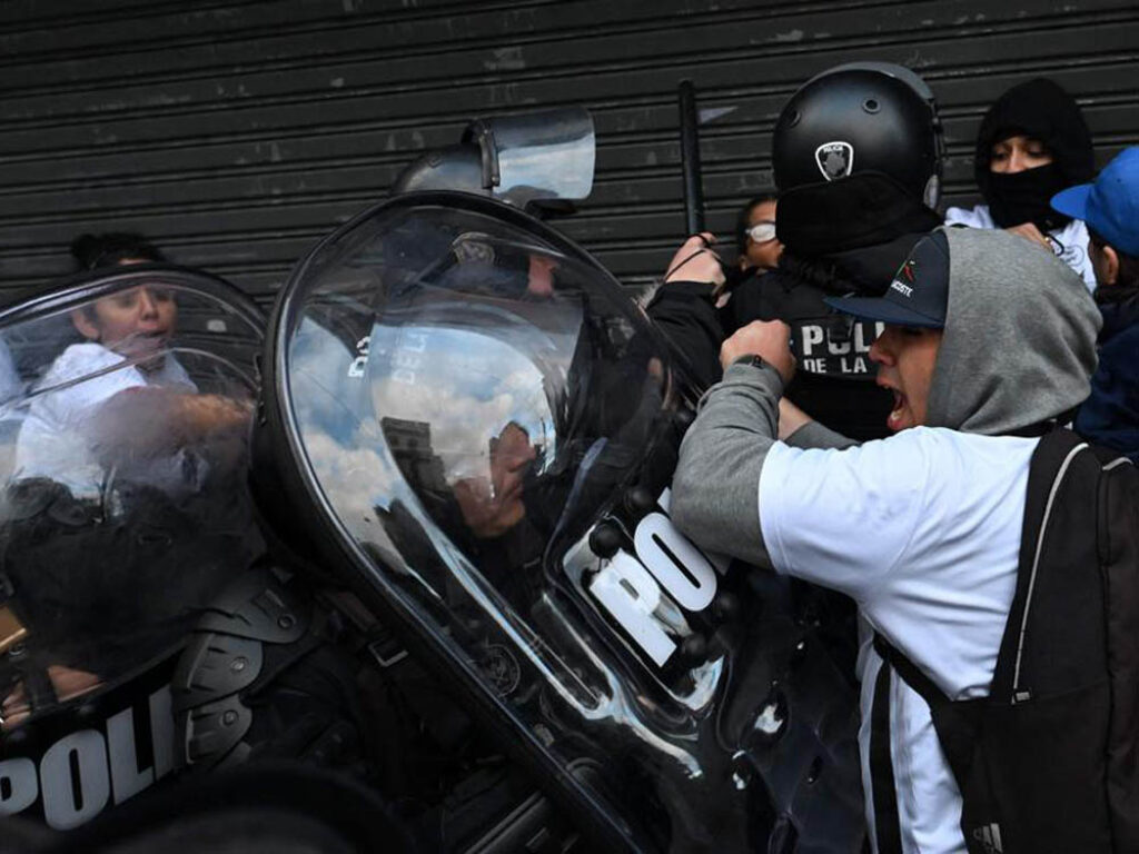 Familiares y amigos de las jóvenes asesinadas se enfrentan a la policía antidisturbios durante una manifestación en Buenos Aires.