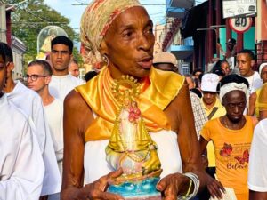 Mujer cubana con Virgen de la Caridad del Cobre