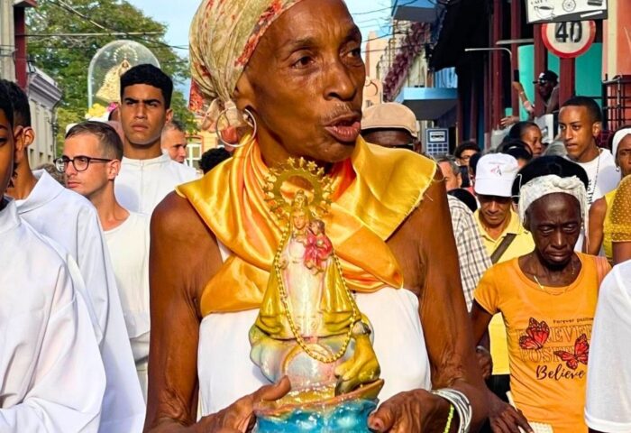 Mujer cubana con Virgen de la Caridad del Cobre