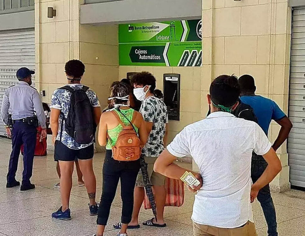 Cubanos hacen fila frente a un cajero automático después de la bancarización.