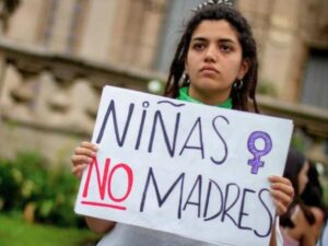 Mujer con cartel sobre la prevención del embarazo en la adolescencia