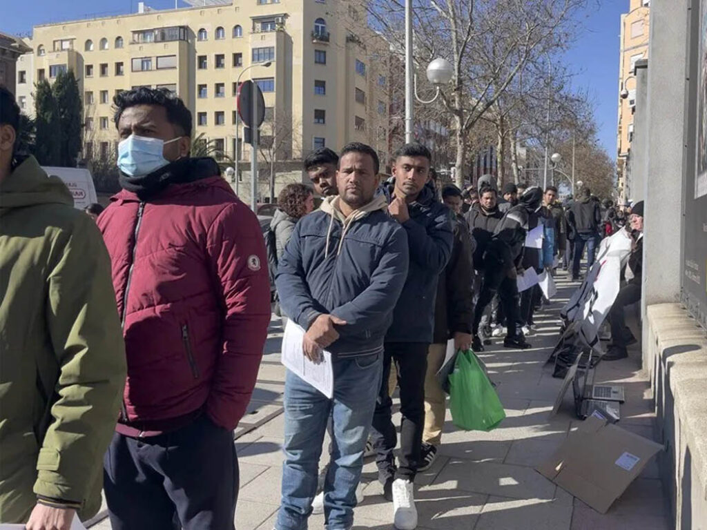 Inmigrantes hacen fila en una oficina de extranjería. Foto: Macarena Soto / EFE