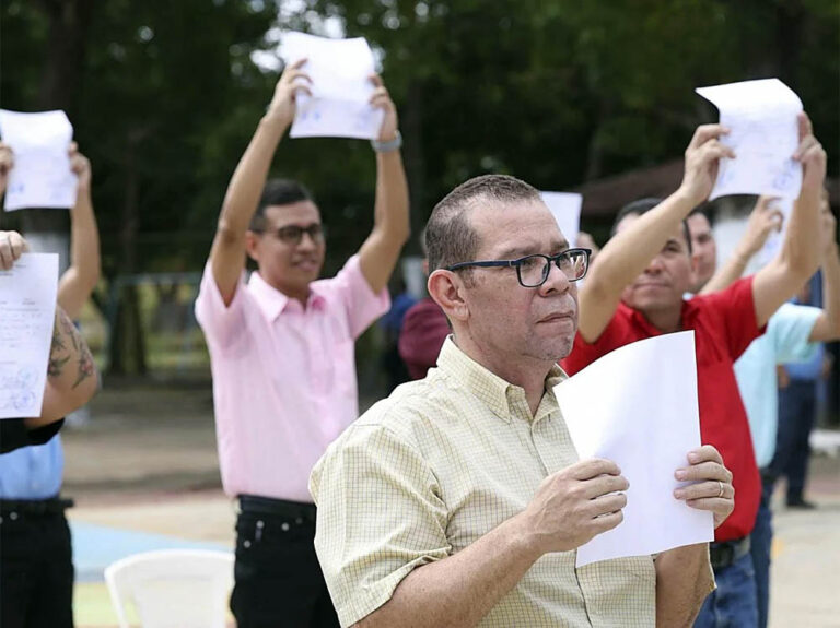Presos políticos liberados por el régimen de Ortega muestran el documento que certifica su excarcelación. Foto: AFP
