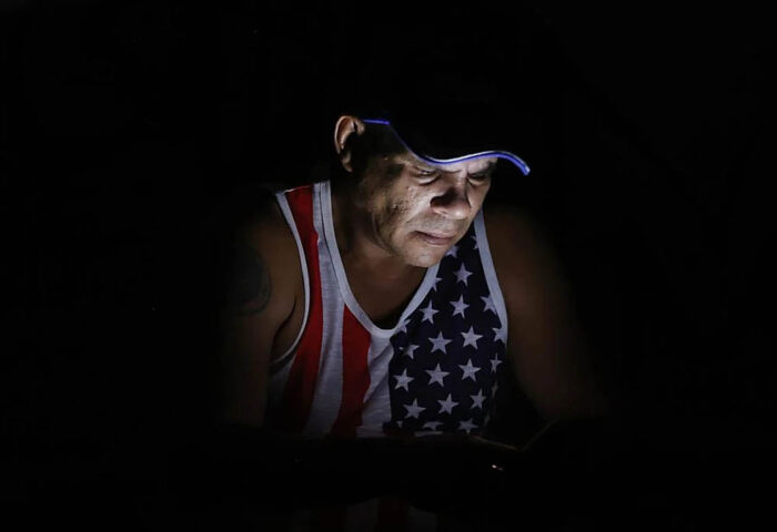 Un cubano revisa su teléfono durante un apagón. Foto: EFE