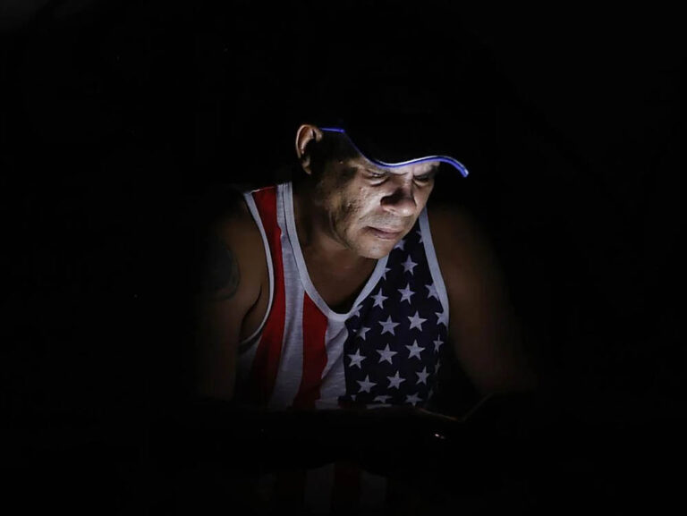 Un cubano revisa su teléfono durante un apagón. Foto: EFE